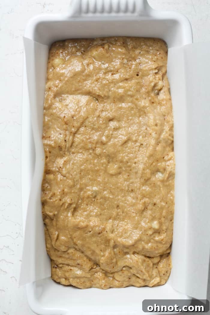 Raw sourdough banana bread batter in a loaf pan.