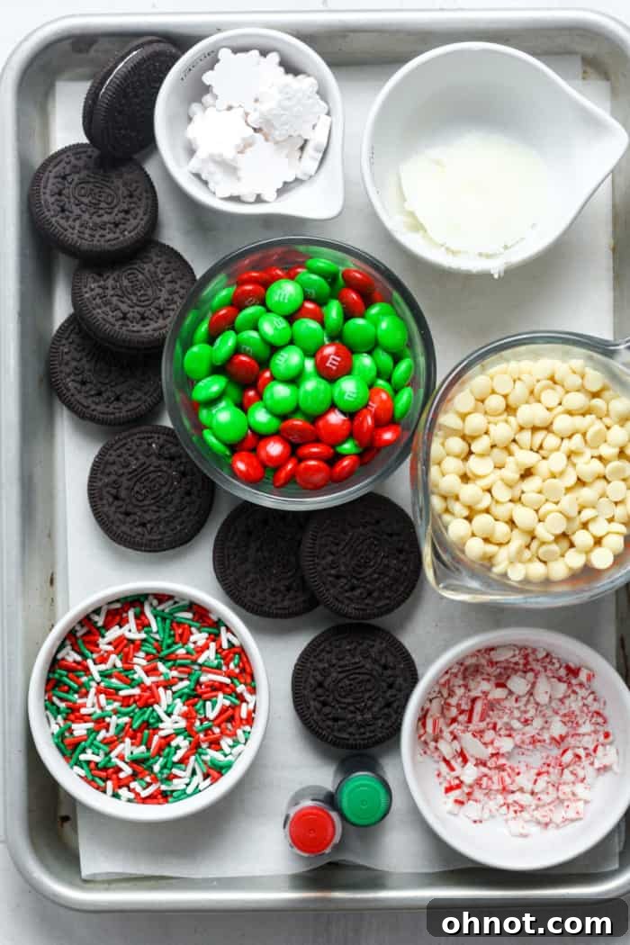 Close-up of freshly dipped and decorated Christmas Oreos on a baking sheet.