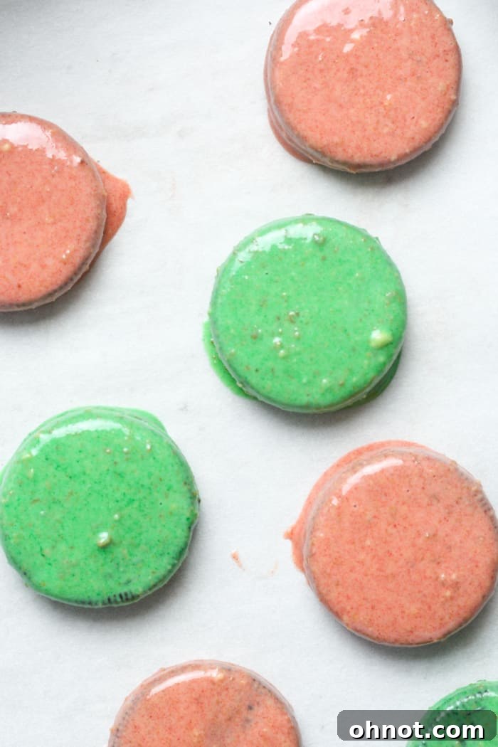 Oreo cookies partially dipped in red and green chocolate, showcasing the vibrant colors.
