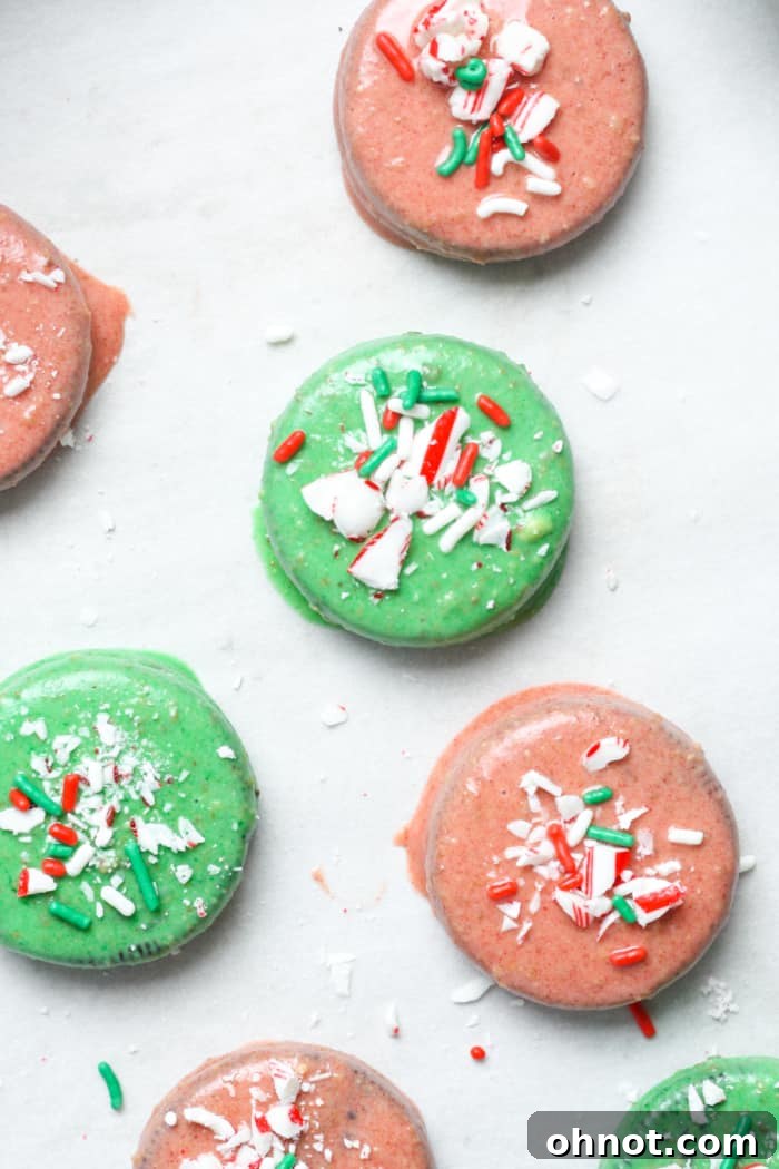 A tray of freshly dipped Christmas Oreos, adorned with sprinkles and crushed candy canes, chilling.