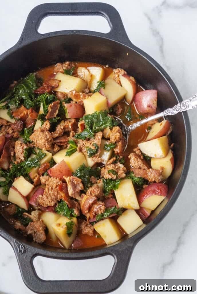 Paleo Zuppa Toscana simmering in a Dutch oven on the stovetop.