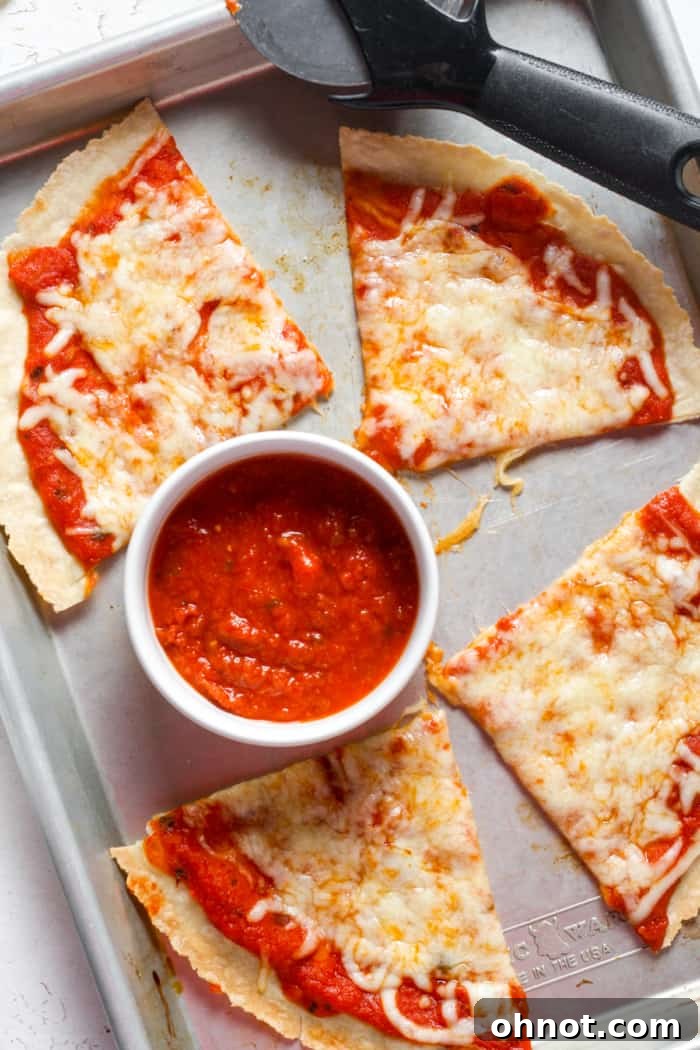 Crispy tortilla pizza, topped with melted cheese and fresh basil, ready to be served.