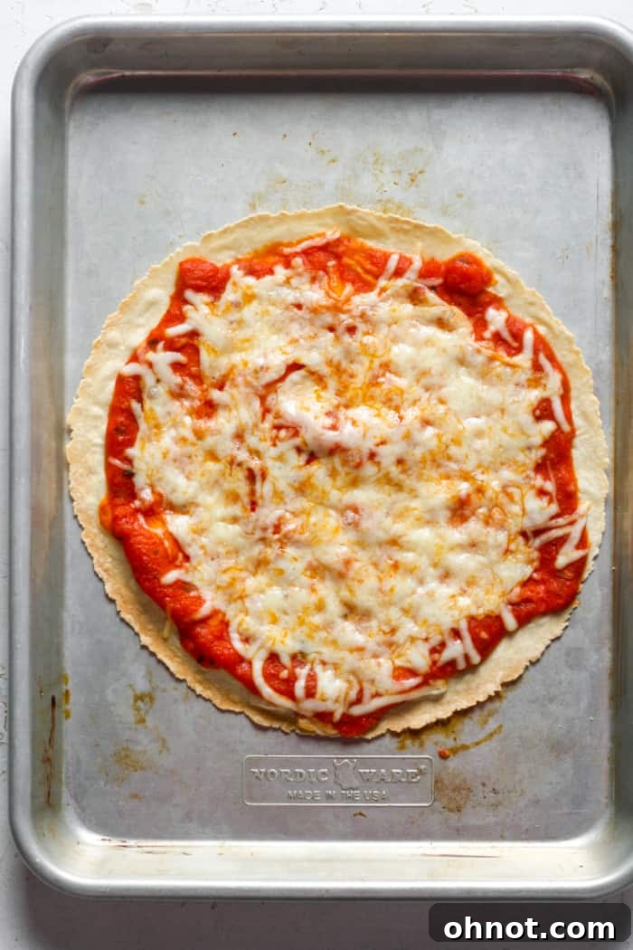 A freshly baked tortilla pizza with golden crust and melted cheese on a baking pan.