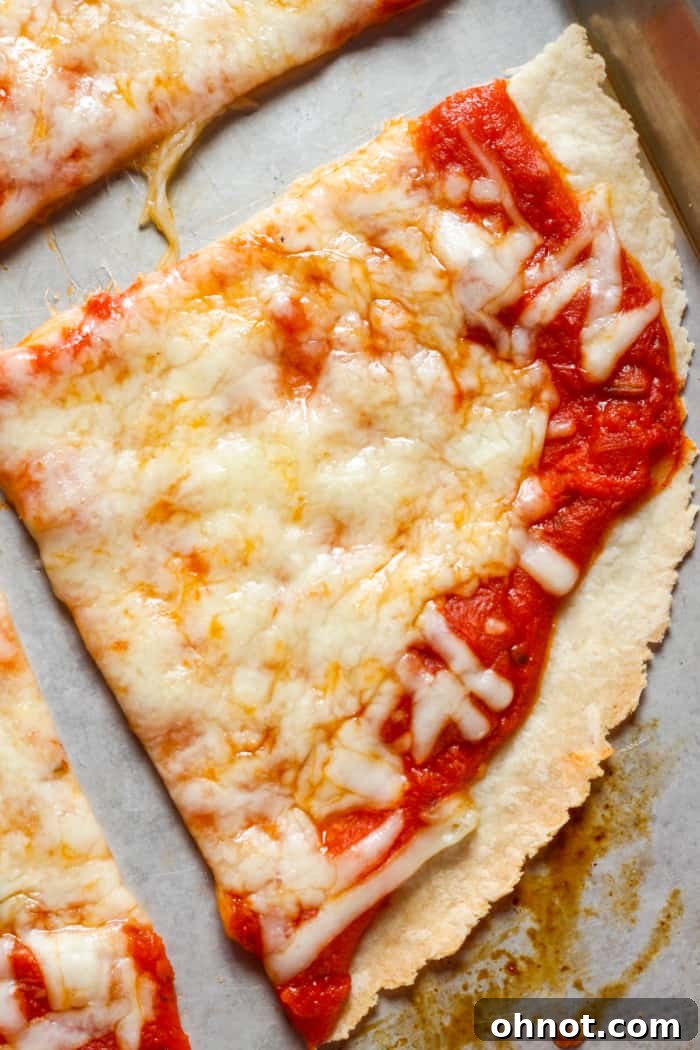 A healthy slice of tortilla pizza topped with fresh basil, ready to be eaten.