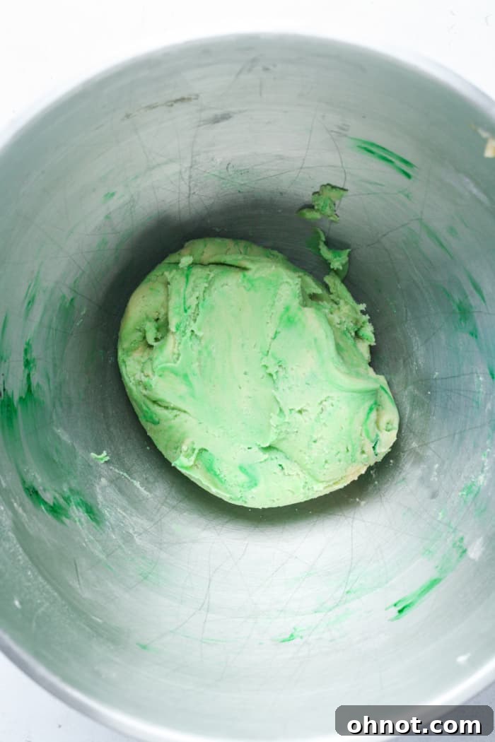 Green colored cookie dough in the mixing bowl.
