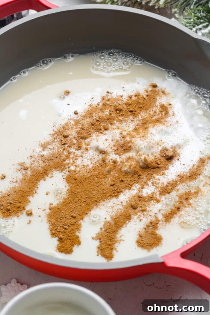 Oat milk and nutmeg being added to a skillet with other ingredients.