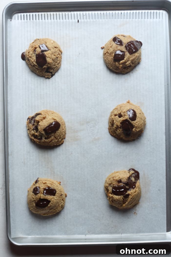 Freshly baked healthier chocolate chip cookies on a baking sheet.