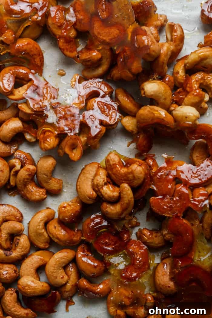 Close-up of golden honey roasted cashews, clumped together with caramelized honey, showcasing their crunchy texture.