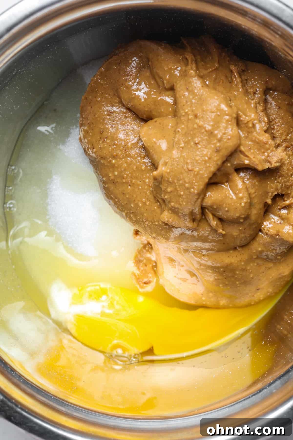 Nut butter, monk fruit, and egg in a mixing bowl before combining.
