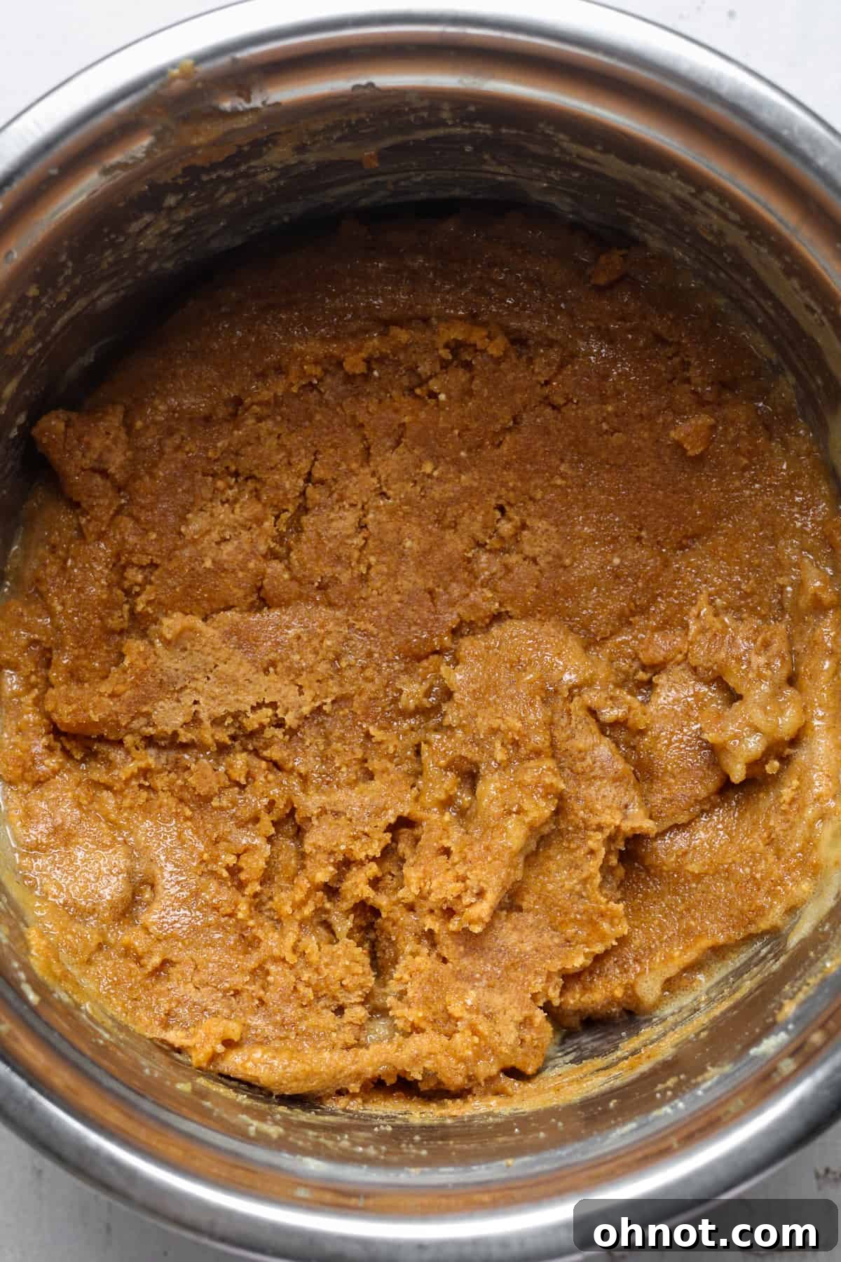 Thick nut butter cookie dough in a bowl after mixing.
