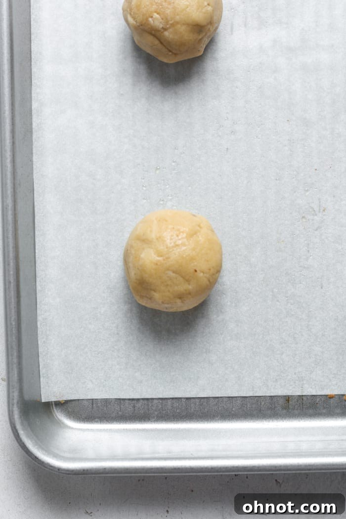 Rolled ball of dough. A single 1-inch ball of espresso cookie dough on a baking sheet.