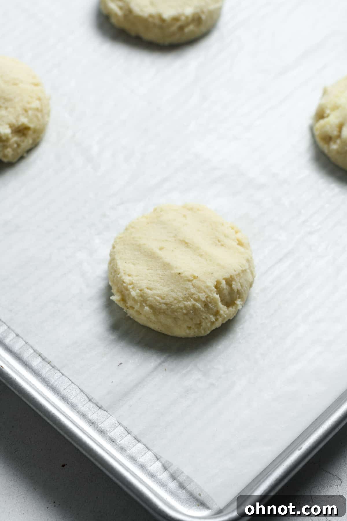 Vegan cookie dough pressed into flat discs on a baking sheet.