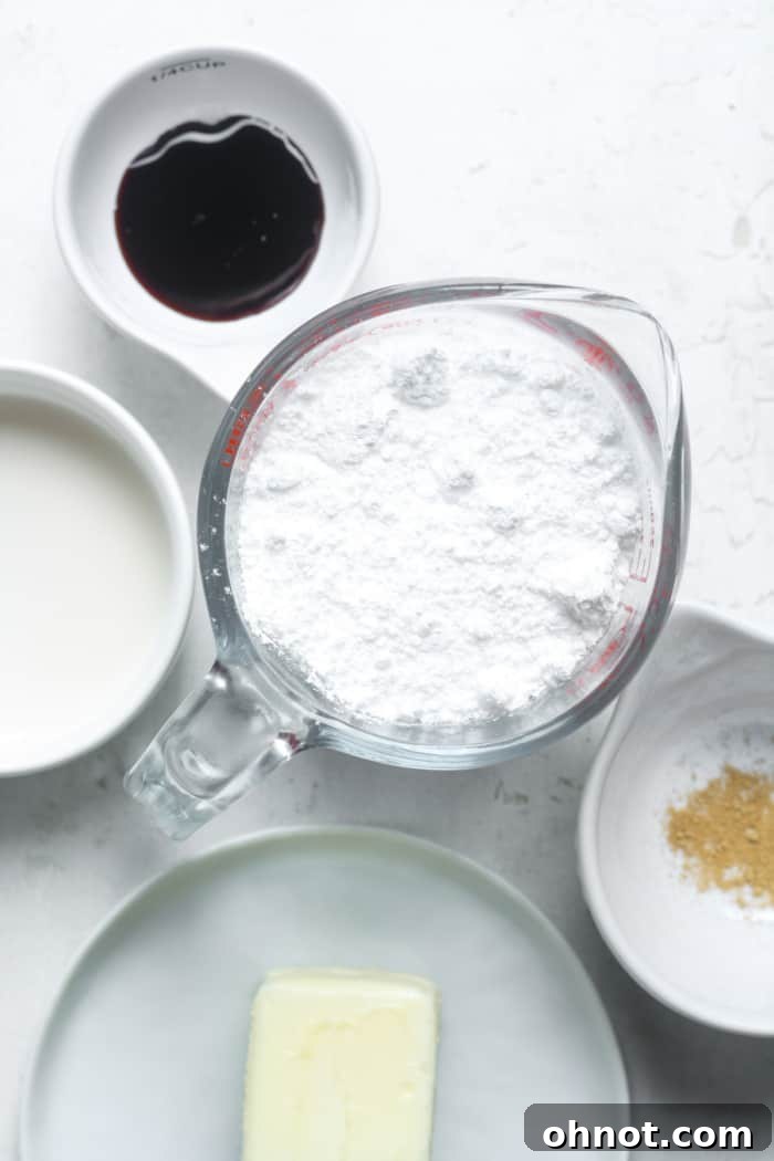 The four simple ingredients laid out for making vegan buttercream: vegan butter, maple syrup, powdered sugar, and dairy-free milk.