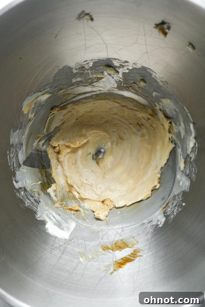 Creamy vegan butter and maple syrup mixture in a stand mixer bowl.