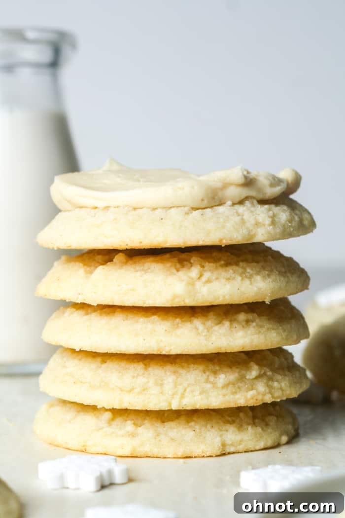 A stack of vegan cookies generously topped with creamy vegan buttercream frosting, ready to be enjoyed.