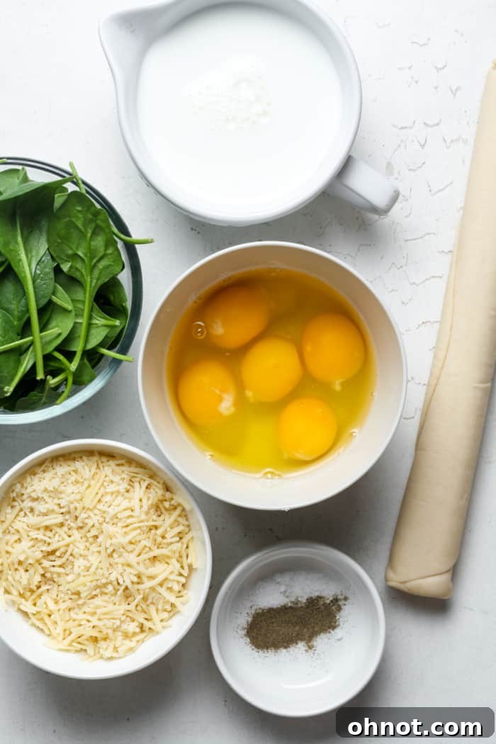 Fresh ingredients for Quiche Florentine laid out on a kitchen counter, including eggs, spinach, Gruyere cheese, and a pie crust.