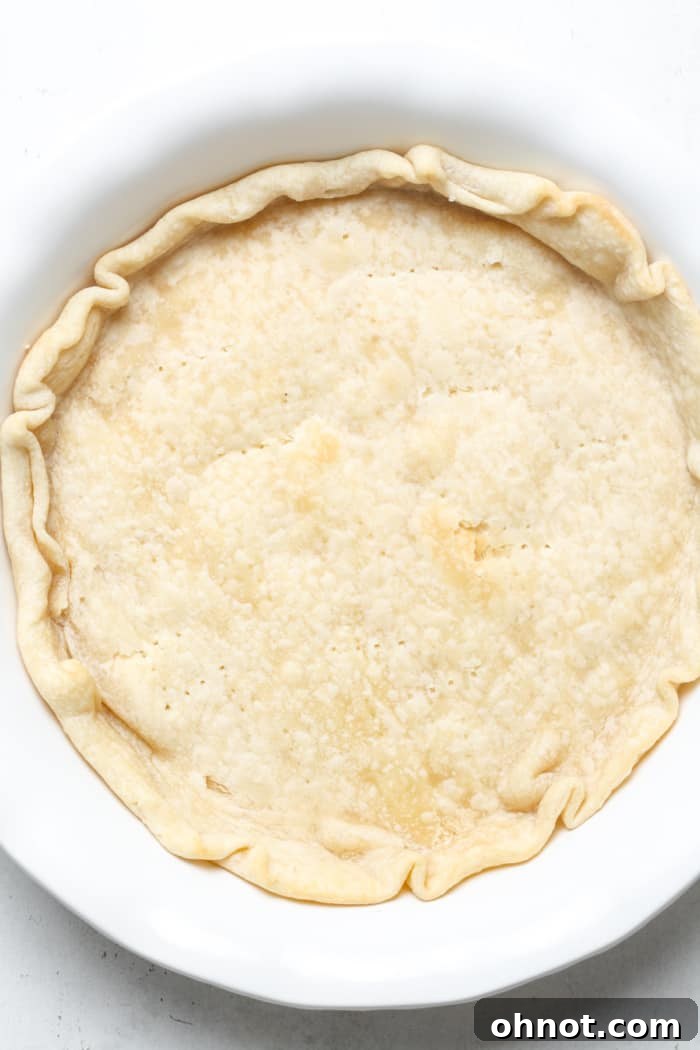 Lightly baked pie crust with a golden edge, just removed from the oven after blind baking.
