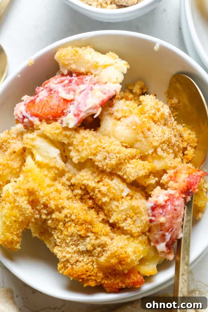 A close-up of a serving of lobster mac and cheese, showcasing the succulent lobster pieces and creamy sauce.