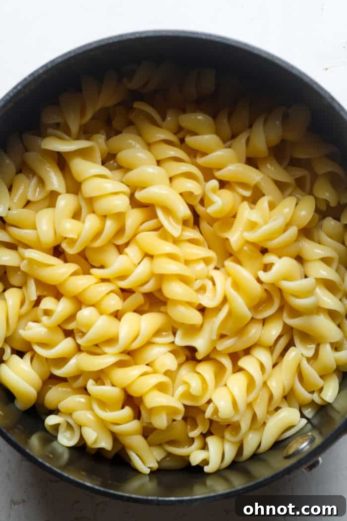 A pot of perfectly cooked cavatappi pasta, drained and ready for the cheese sauce.