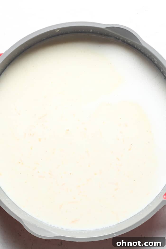 A creamy, cheesy mixture in a skillet, with melted Gruyère and cheddar, seasoned to perfection.