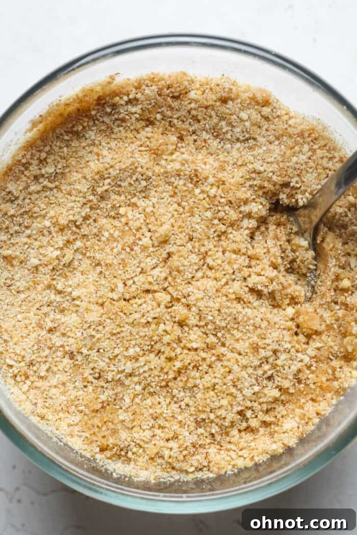 Golden breadcrumbs mixed with melted butter in a small bowl, ready to top the mac and cheese.