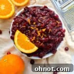 Paleo cranberry sauce in bowl with sliced orange