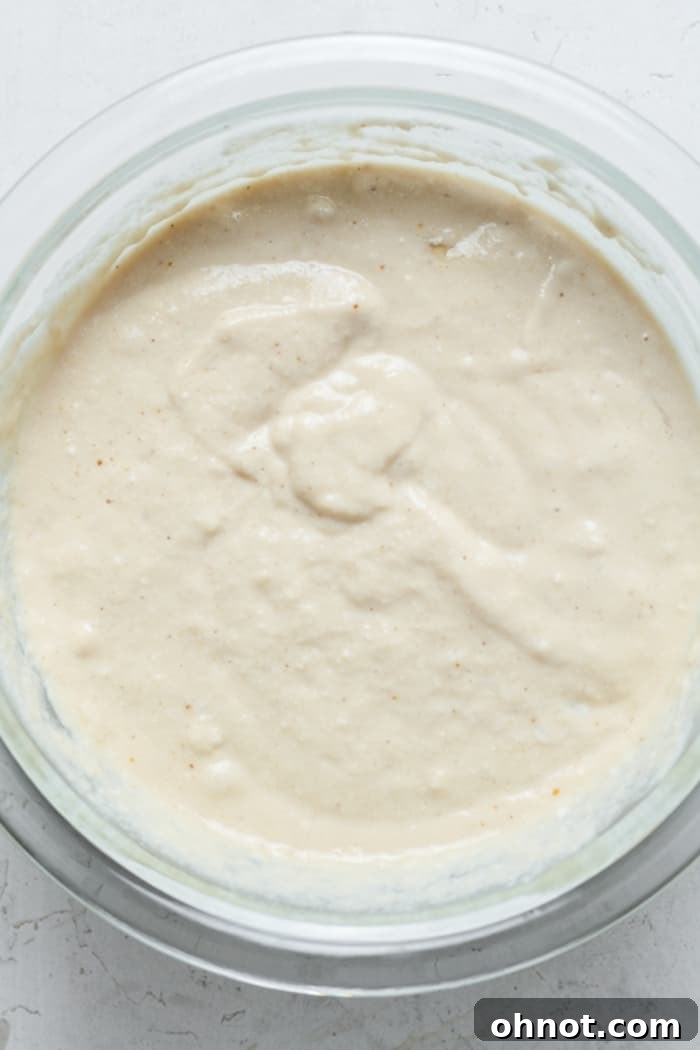 Sourdough pancake batter in a mixing bowl, showing a slightly lumpy but combined consistency.