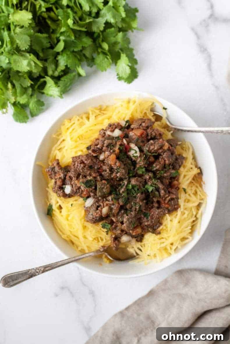 Taco Stuffed Spaghetti Squash: A delicious and healthy fusion recipe featuring ground beef and fresh vegetables in a roasted spaghetti squash boat.