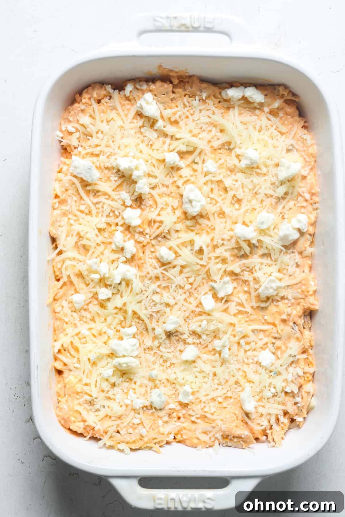 The dip in the pan, topped generously with mozzarella and crumbled blue cheese, ready for the oven.