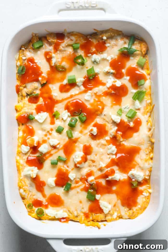 The finished dip, garnished with fresh green onions and a drizzle of hot sauce, ready to be enjoyed.
