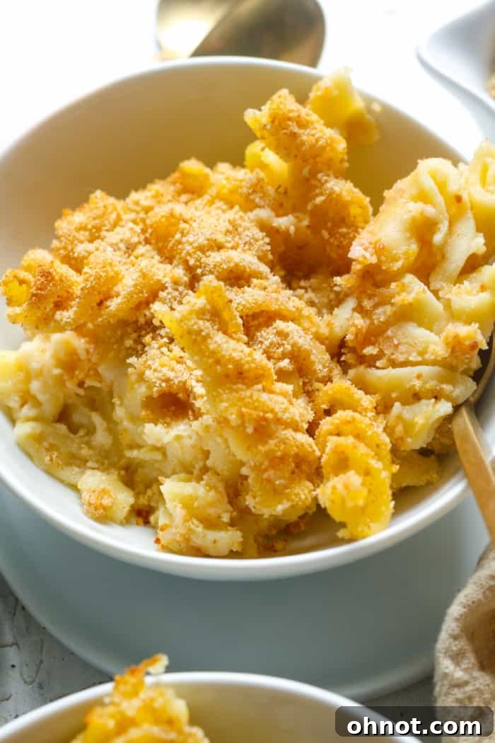 Close-up of baked gluten-free mac and cheese in a dish, showing the pasta coated in sauce and the breadcrumb topping.