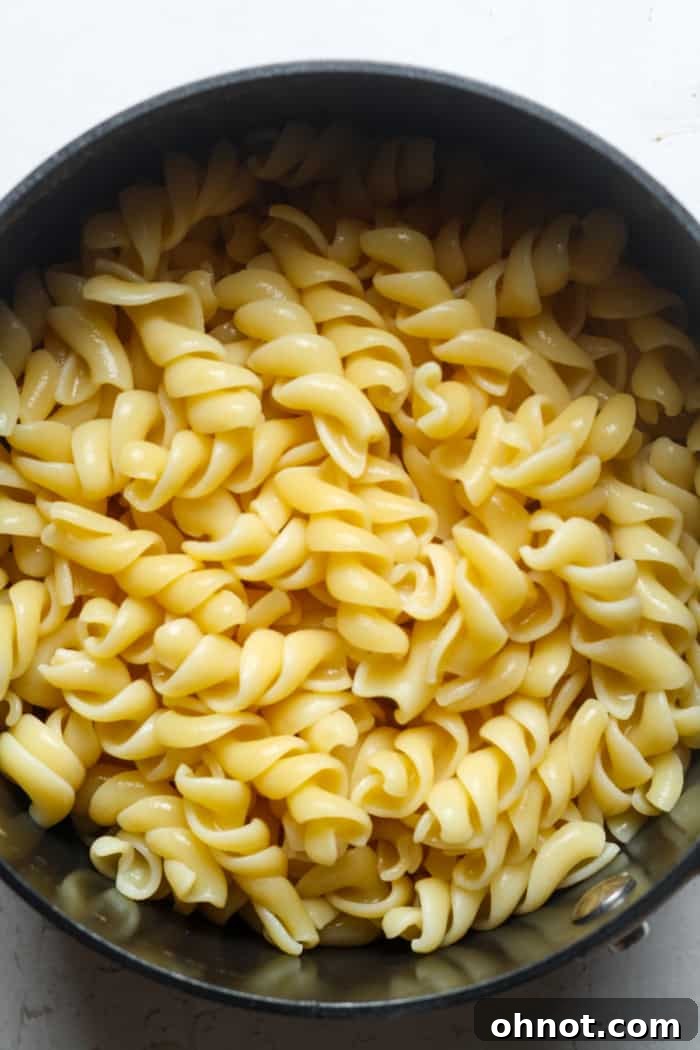 A bowl of cooked gluten-free pasta, drained and ready for the cheese sauce.