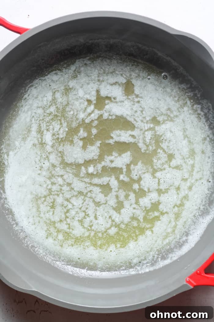 Melted butter shimmering in a skillet over low heat.