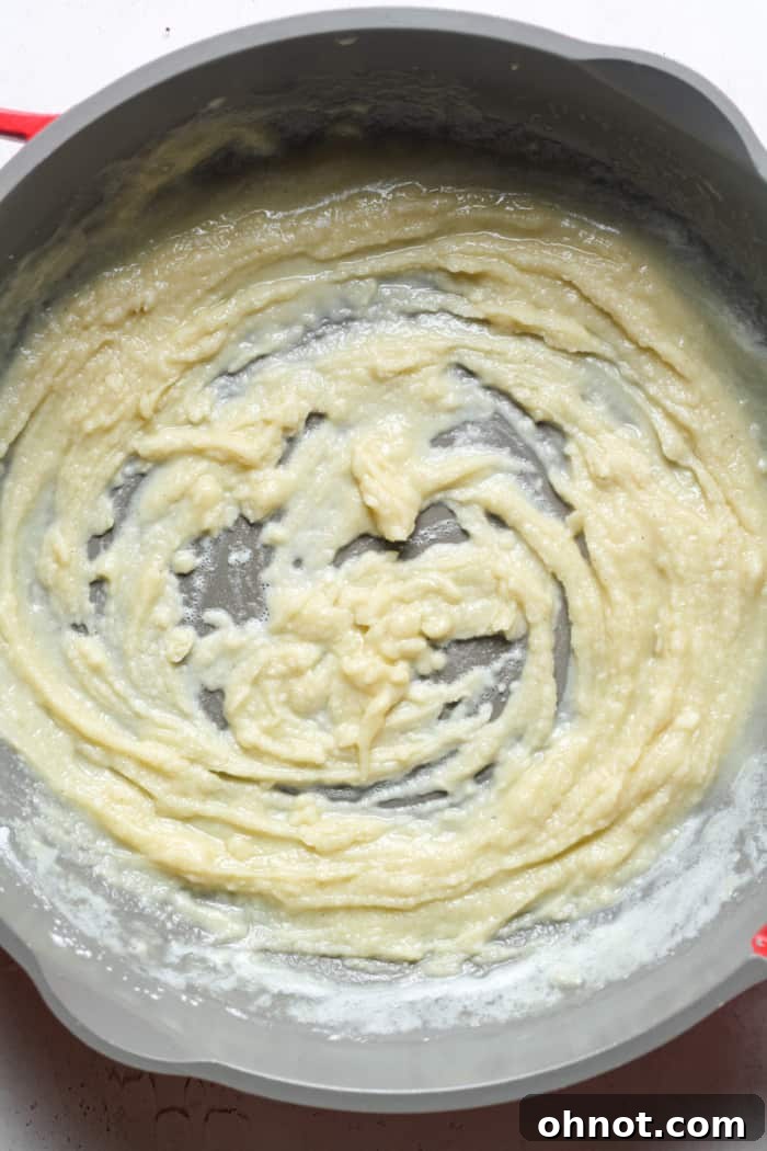 A smooth, golden slurry of butter and gluten-free flour in a pan.