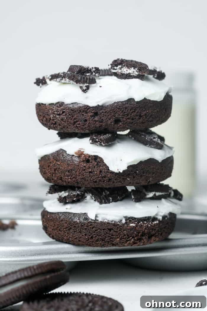 A stack of perfectly frosted chocolate Oreo pastries, garnished with crumbs.