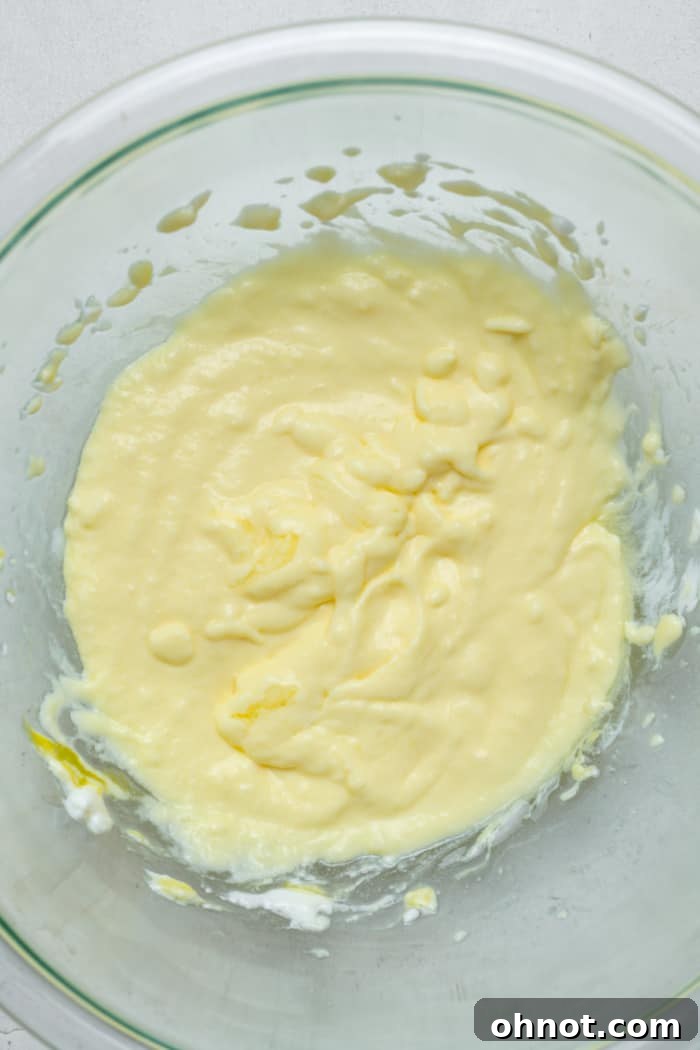 Smooth and well-combined wet ingredients for the donut batter in a mixing bowl.