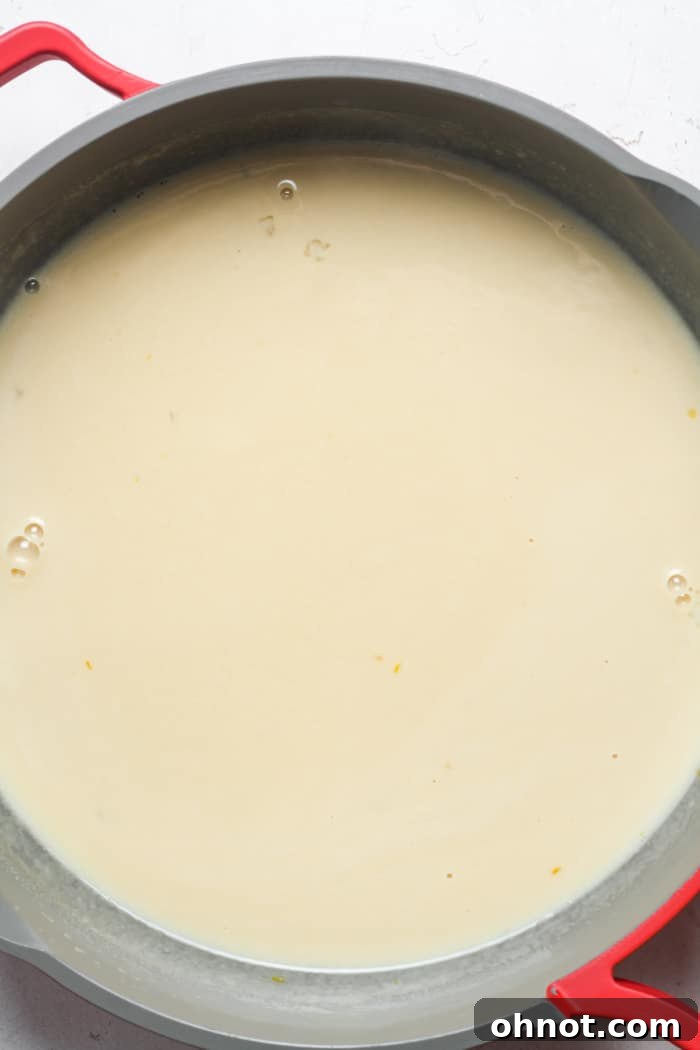 Creamy egg and half and half mixture cooking in a pan, forming a custard.