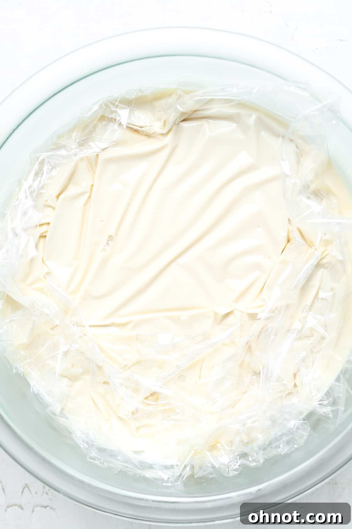 Plastic wrap being removed from chilled custard.