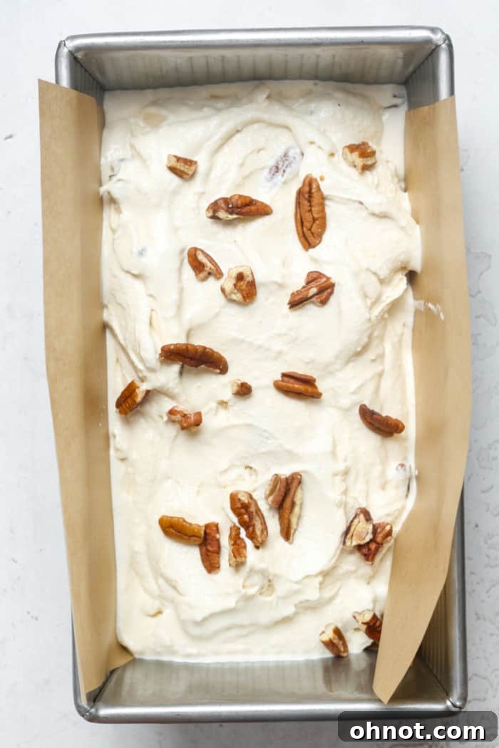 Freshly churned butter pecan ice cream transferred to a pan for freezing.