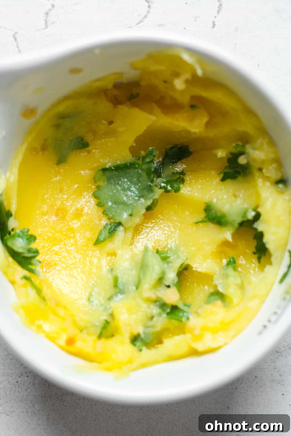 Freshly made garlic herb butter in a small white bowl.
