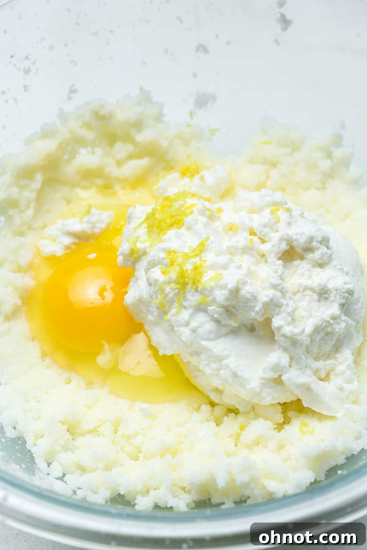 Close-up of lemon zest being added to cookie dough mixture.