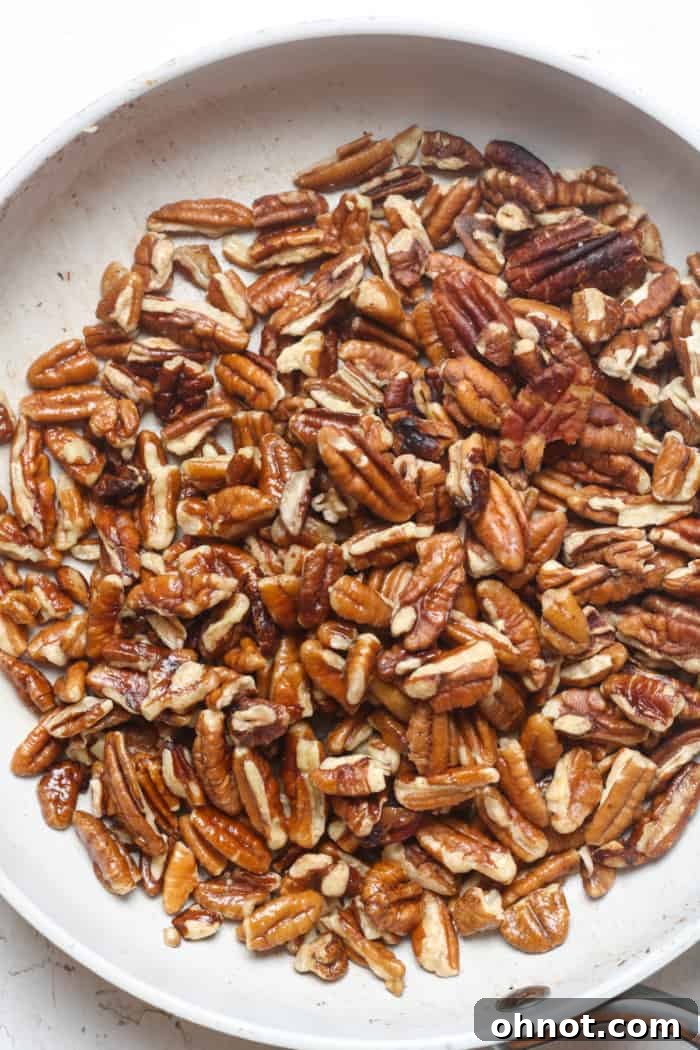 Pecans toasting in butter in a skillet.