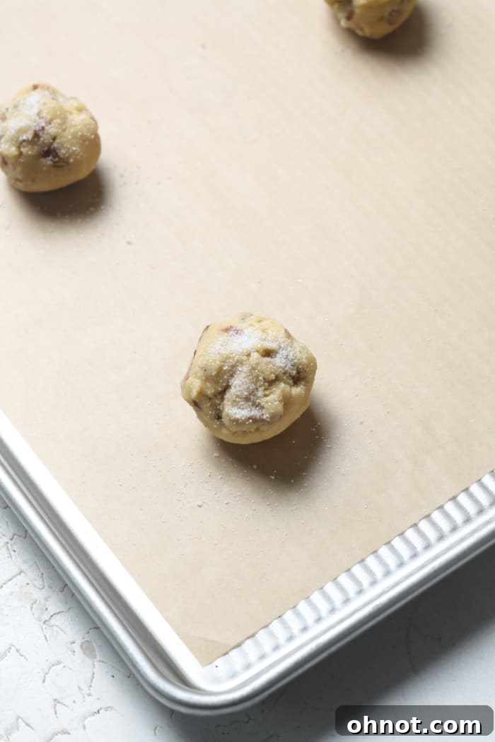 Balls of pecan cookie dough on a baking sheet.