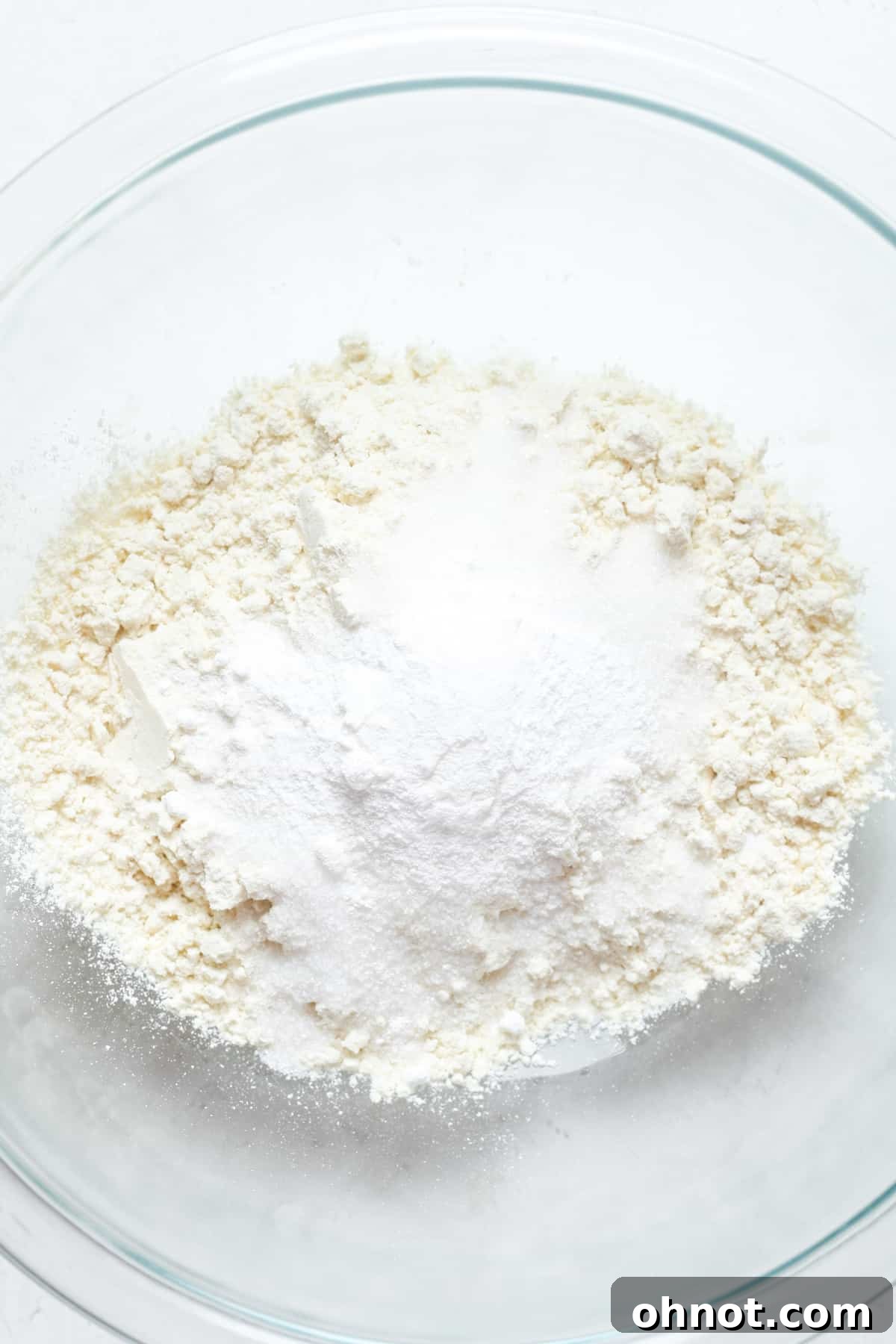 Dry ingredients for waffles: flour and white sugar in a mixing bowl.