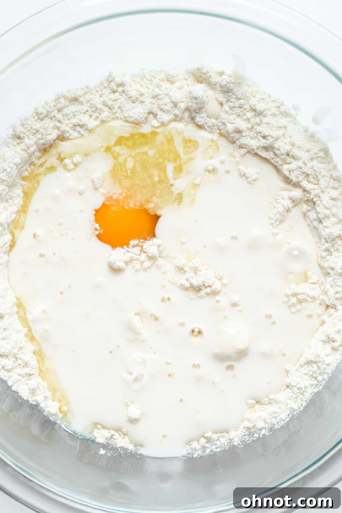Waffle batter showing wet ingredients not yet fully mixed.