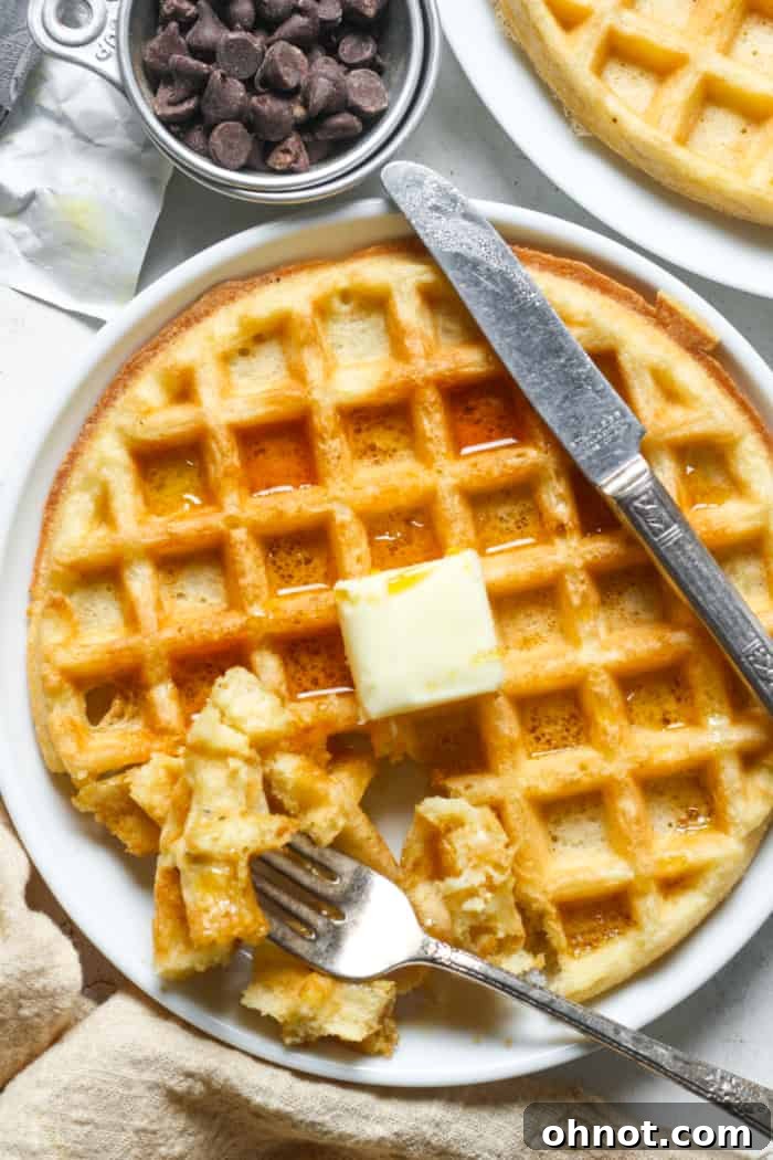 Breakfast waffle topped with maple syrup, ready to eat.