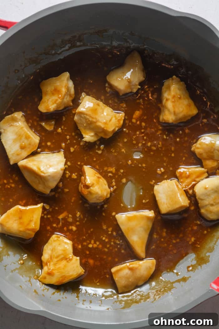 Finished Chinese garlic chicken with a thick, glossy sauce, garnished with green onions.