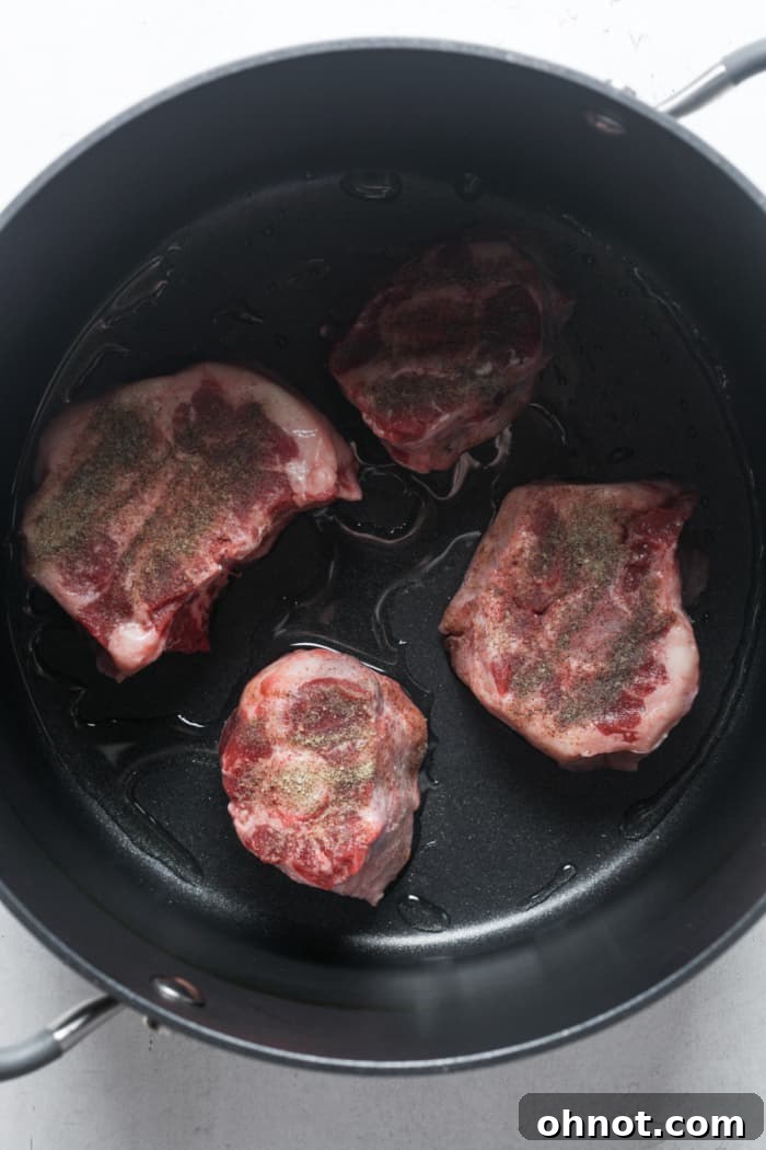 Beef oxtail meat searing in a stew pot.