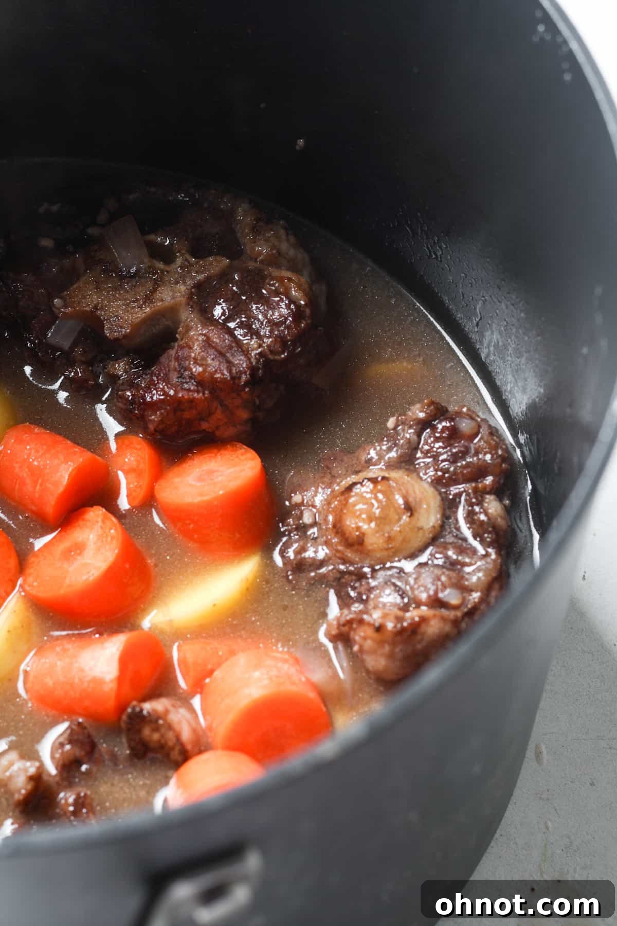 Meat stew with added vegetables in a pot.