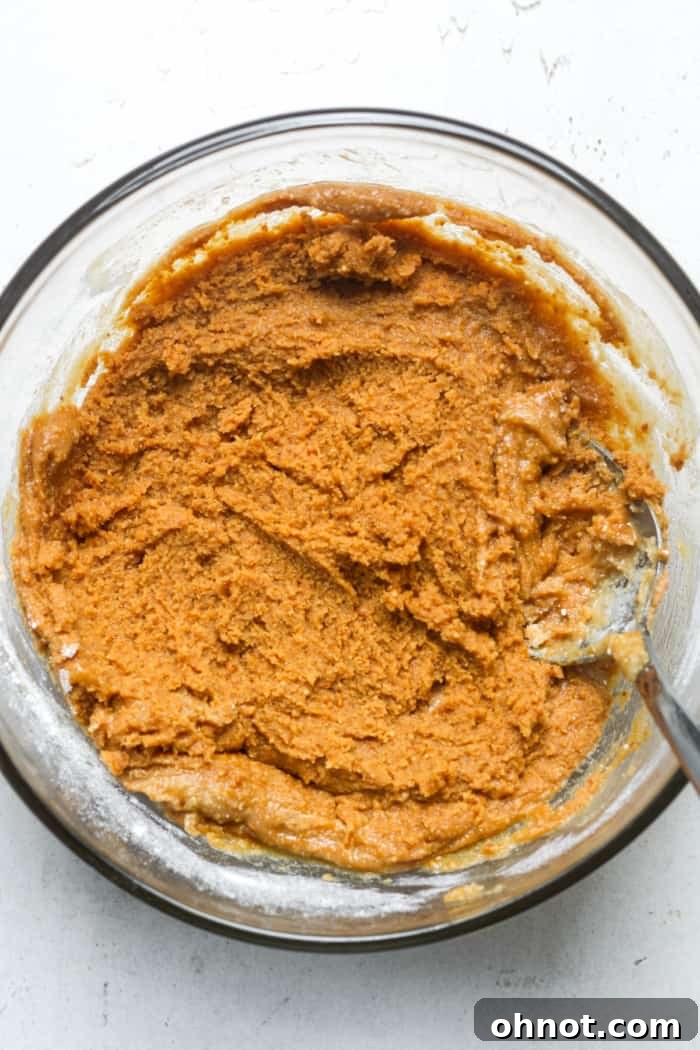 Thick peanut butter mixture in a bowl, ready to be rolled.